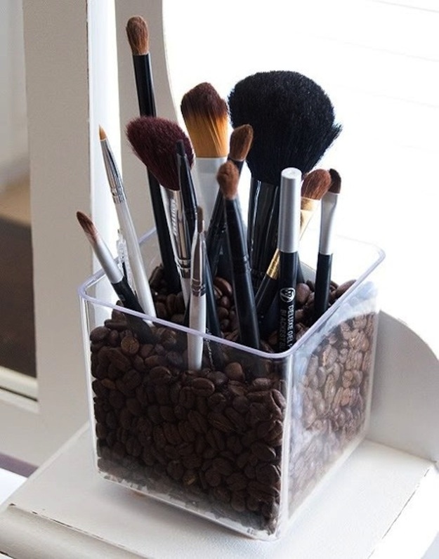 Fill a votive holder with coffee beans and keep your brushes in it.